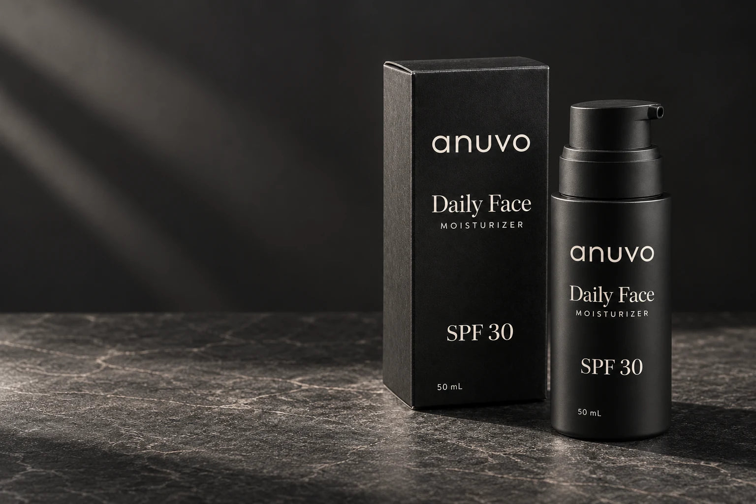 Anuvo Daily Face black pump bottle and carton on charcoal stone